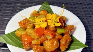 Prato de comida com legumes e carne, decorado com flores amarelas.