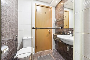 A bathroom with a shower, toilet, sink, and a wooden door. - Modern and Central 1 BD in the Marina (Dubai)