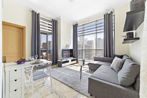 Una sala de estar moderna con sofá, mesa de comedor y televisor.