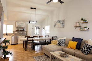 A spacious living room with a beige sofa, wooden dining table, and a ceiling fan. - Lucky Kentucky Ranch Home- Visit Ark & Creation Museum (Erlanger)