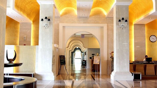 A spacious lobby with a marble floor, a reception desk, and a chandelier. - Happiness CC Hotel (Naju)