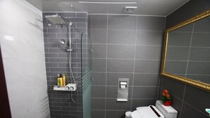 A modern bathroom with a shower, toilet, and sink. - Happiness CC Hotel (Naju)