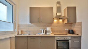 Eine kompakte Küche mit Einbauofen, Kaffeemaschine und Toaster.