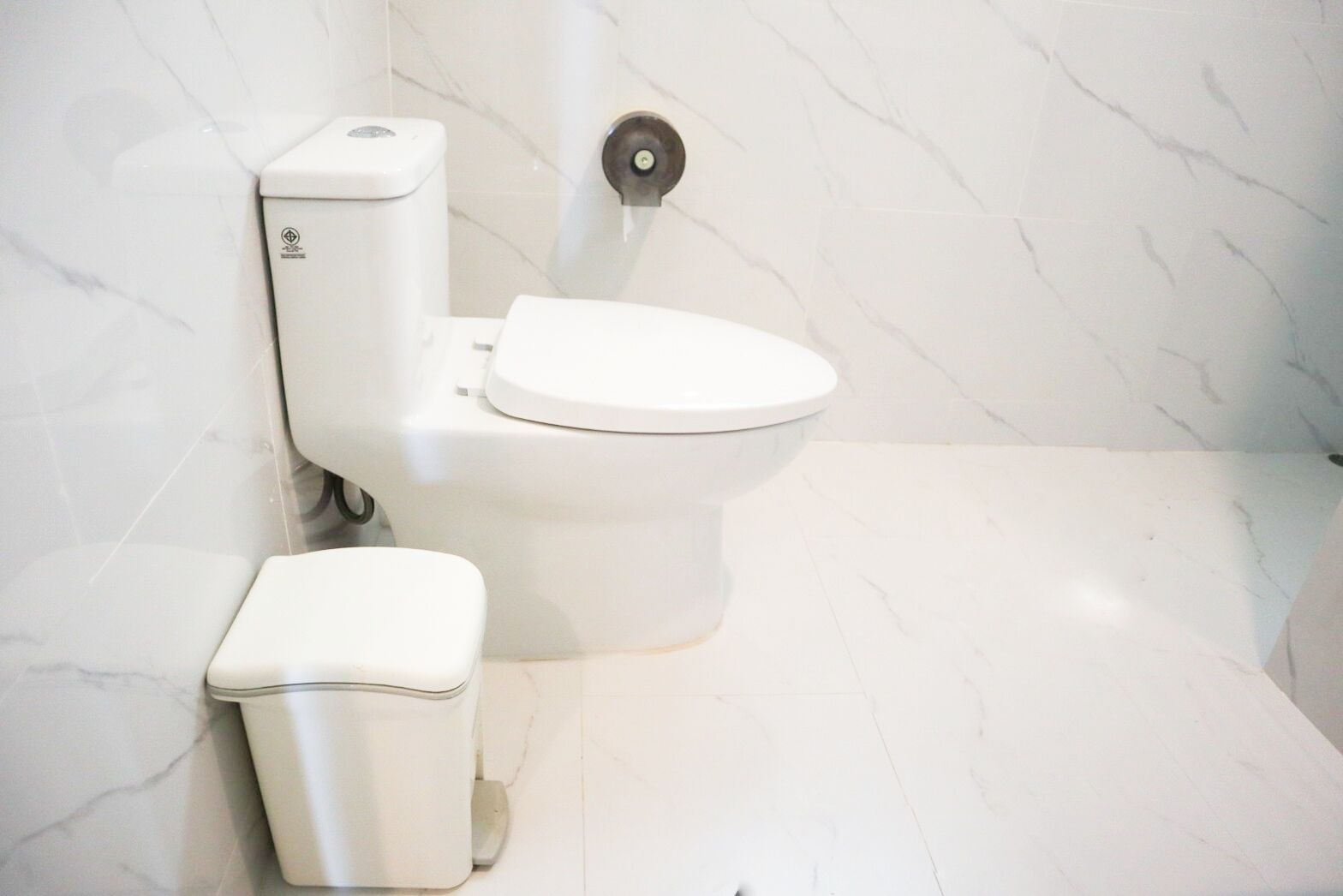 Une salle de bain moderne avec des toilettes, un bidet et un sol en marbre.