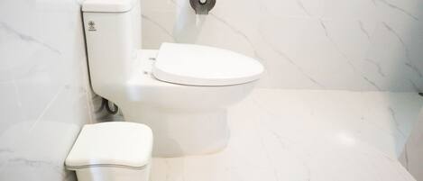Une salle de bain moderne avec des toilettes, un bidet et un sol en marbre.