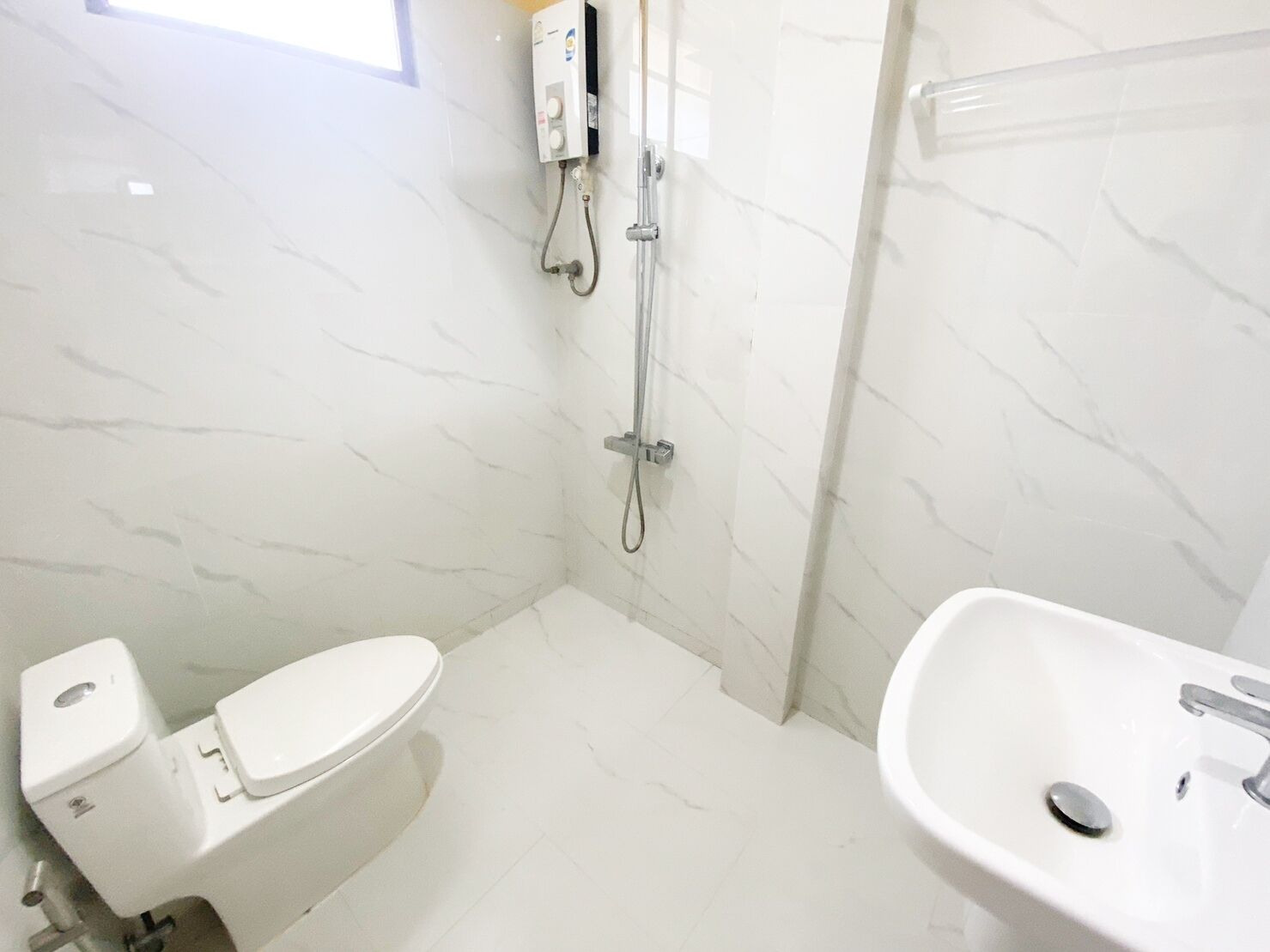 A bathroom with a toilet, a sink, and a shower.