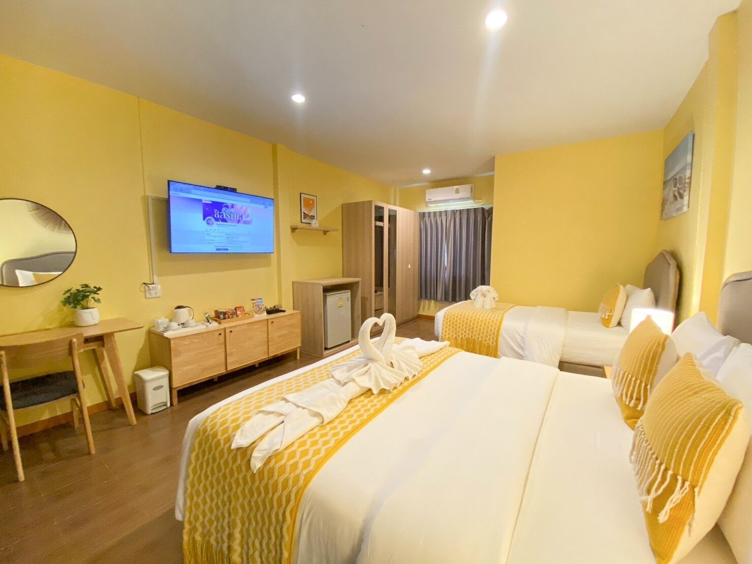 Une chambre d’hôtel avec deux lits, un bureau, une télévision, une armoire et une salle de bain.