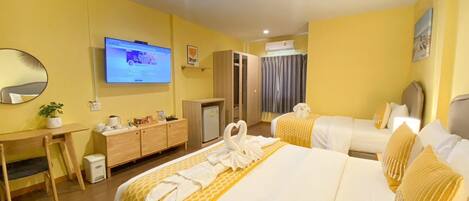 Une chambre d’hôtel avec deux lits, un bureau, une télévision, une armoire et une salle de bain.