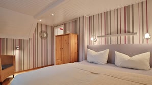 Een slaapkamer met een bed, een kledingkast en een stoel.