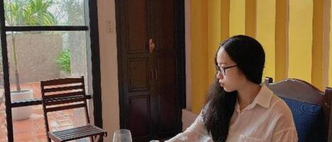 Una mesa de comedor dispuesta con platos, una botella y un ramo de flores.