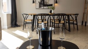 Ein Essbereich mit einem Tisch für zwei Personen, einer Champagnerflasche und zwei Gläsern.