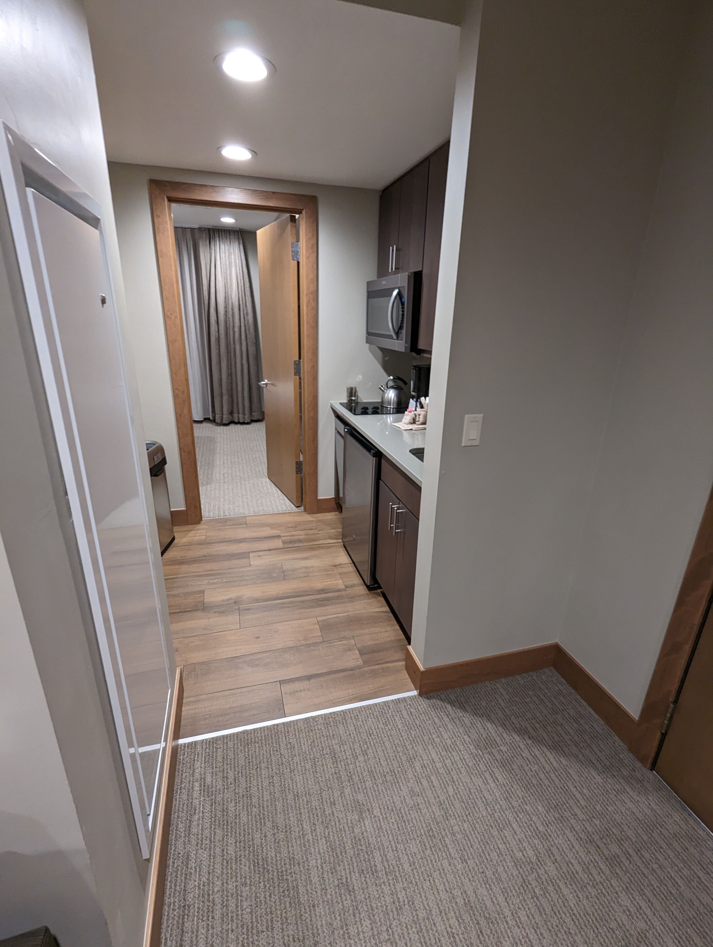 A compact kitchen with a microwave, stove, and cabinets.