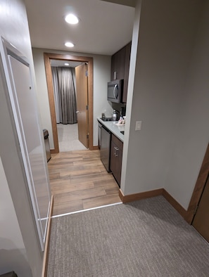 A compact kitchen with a microwave, stove, and cabinets.
