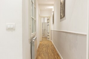 A narrow hallway with wooden flooring, white walls, and a radiator. - Fiesolana Loft - Florence (Firenze)