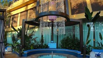 A spacious atrium with a central pool, surrounded by seating areas and lush greenery.