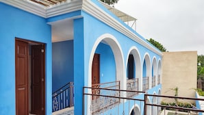 A blue building with a tiled entrance, a staircase with metal railings, and a small pool area. - Casa Azulí Santiago  (Mérida)