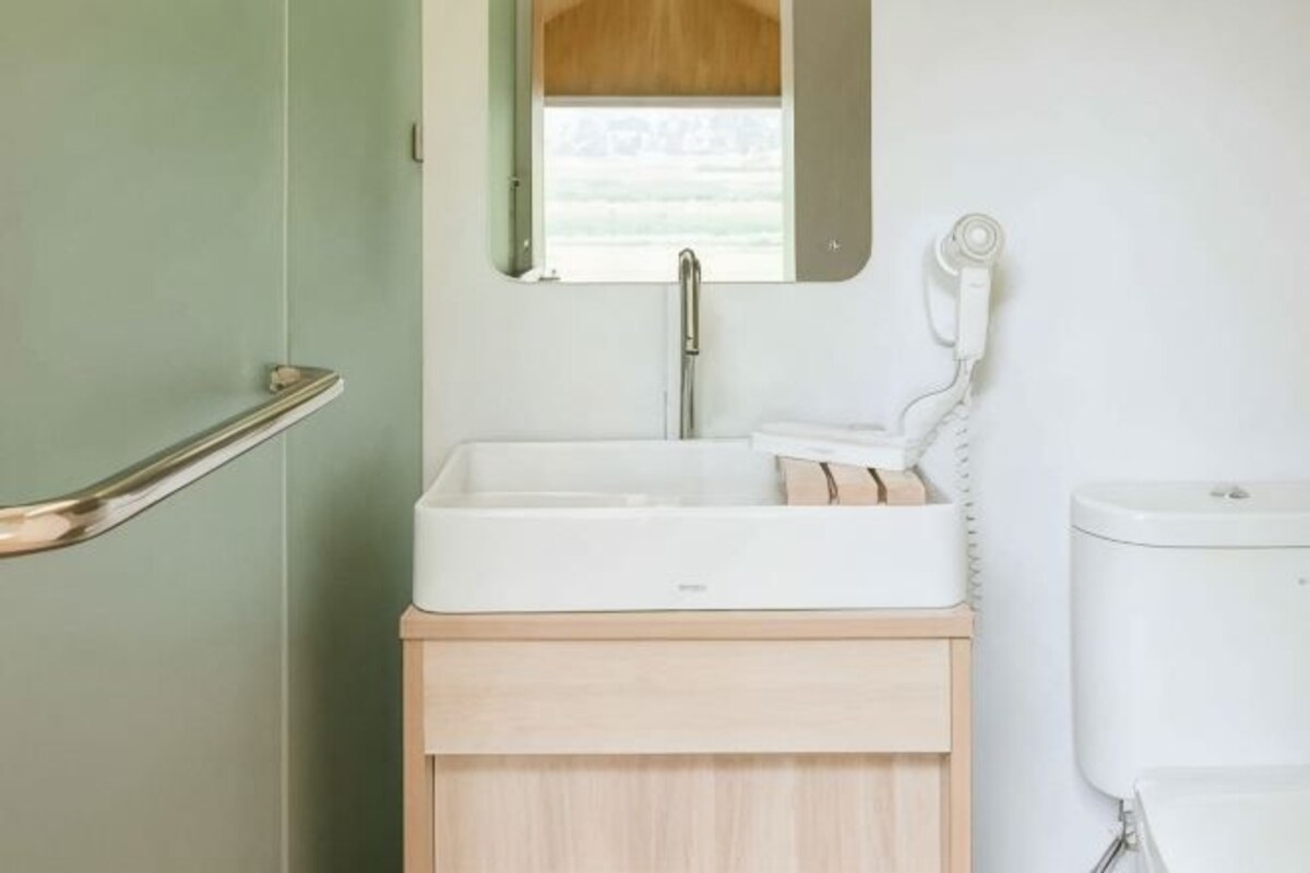 A bathroom with a white sink, a mirror, and a toilet.