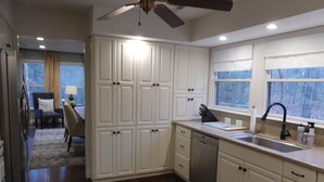 A modern kitchen with white cabinetry, a dishwasher, and a window with a view. - Charming 3 BR, 2 Bath cabin located in quiet Clifftops and close to Sewanee (Monteagle)