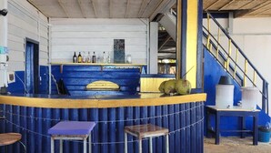 A bar area with a counter, stools, and a staircase. - Cocohuts Cambodia (Koh Rong Sanloem)