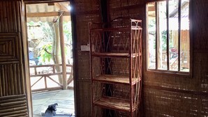 A rustic wooden room with a metal shelf unit and a window. - Cocohuts Cambodia (Koh Rong Sanloem)