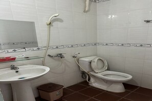 A bathroom with a sink, toilet, and shower. - Thuy Duong Hotel Binh Duong (Ho Chi Minh City)