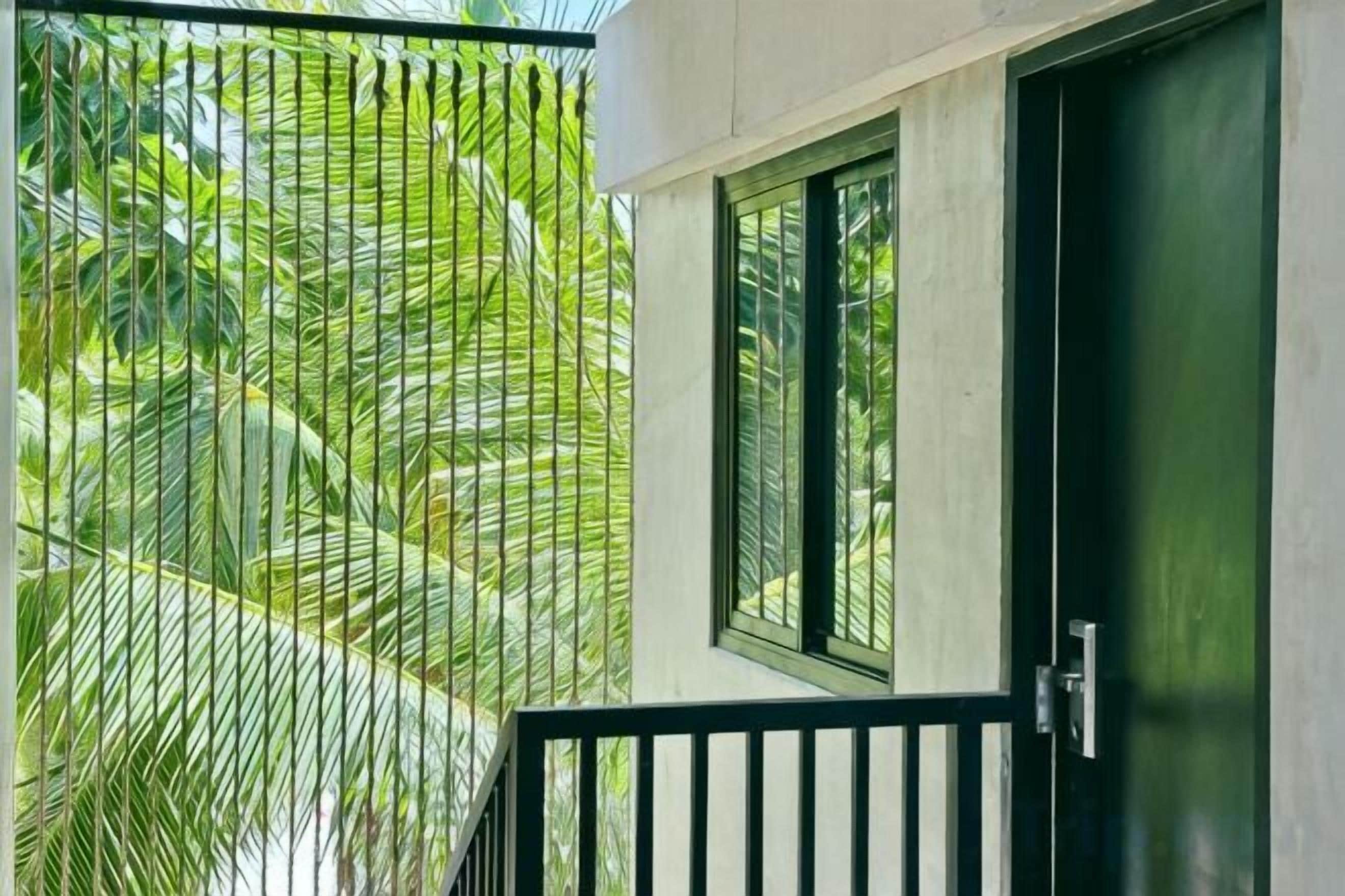 A balcony with a black railing, a door, and a window.