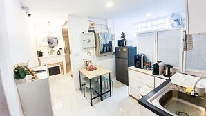 Una cocina compacta con un lavabo, un refrigerador y un pequeño comedor con sillas.