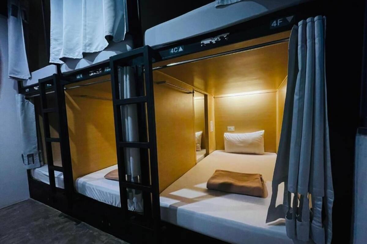 Een slaapkamer met een stapelbed, een tafeltje en een lamp.