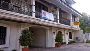 A two-story building with a balcony, a banner, and a sign for MetroVigan Inn. - Metro Vigan Inn - Annex (Vigan)