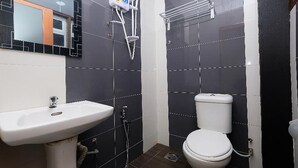 Ein Badezimmer mit einem weißen Waschbecken, einer Toilette und einer Duschkabine.