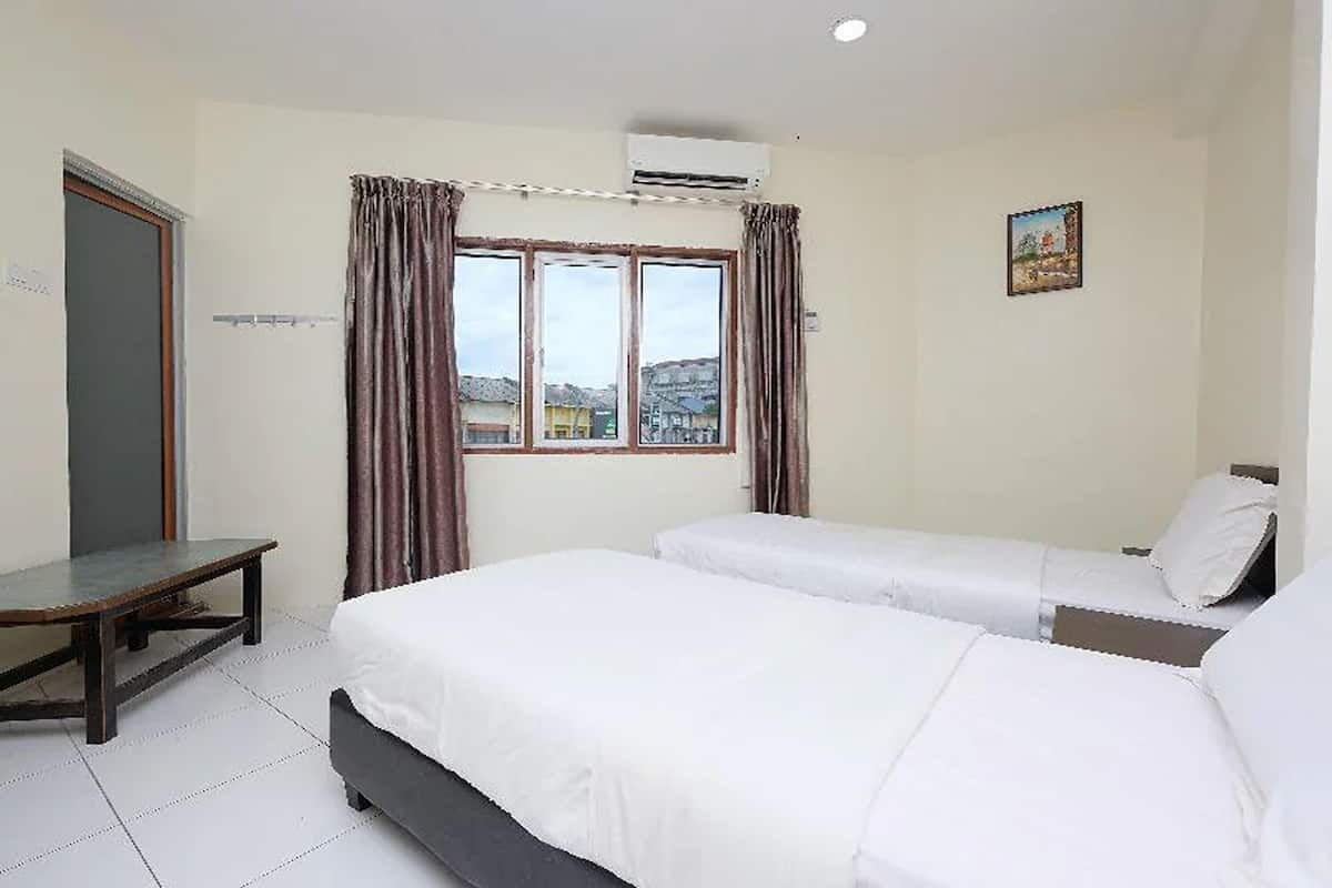A hotel room with two beds, a window with curtains, a small table, and a painting on the wall.