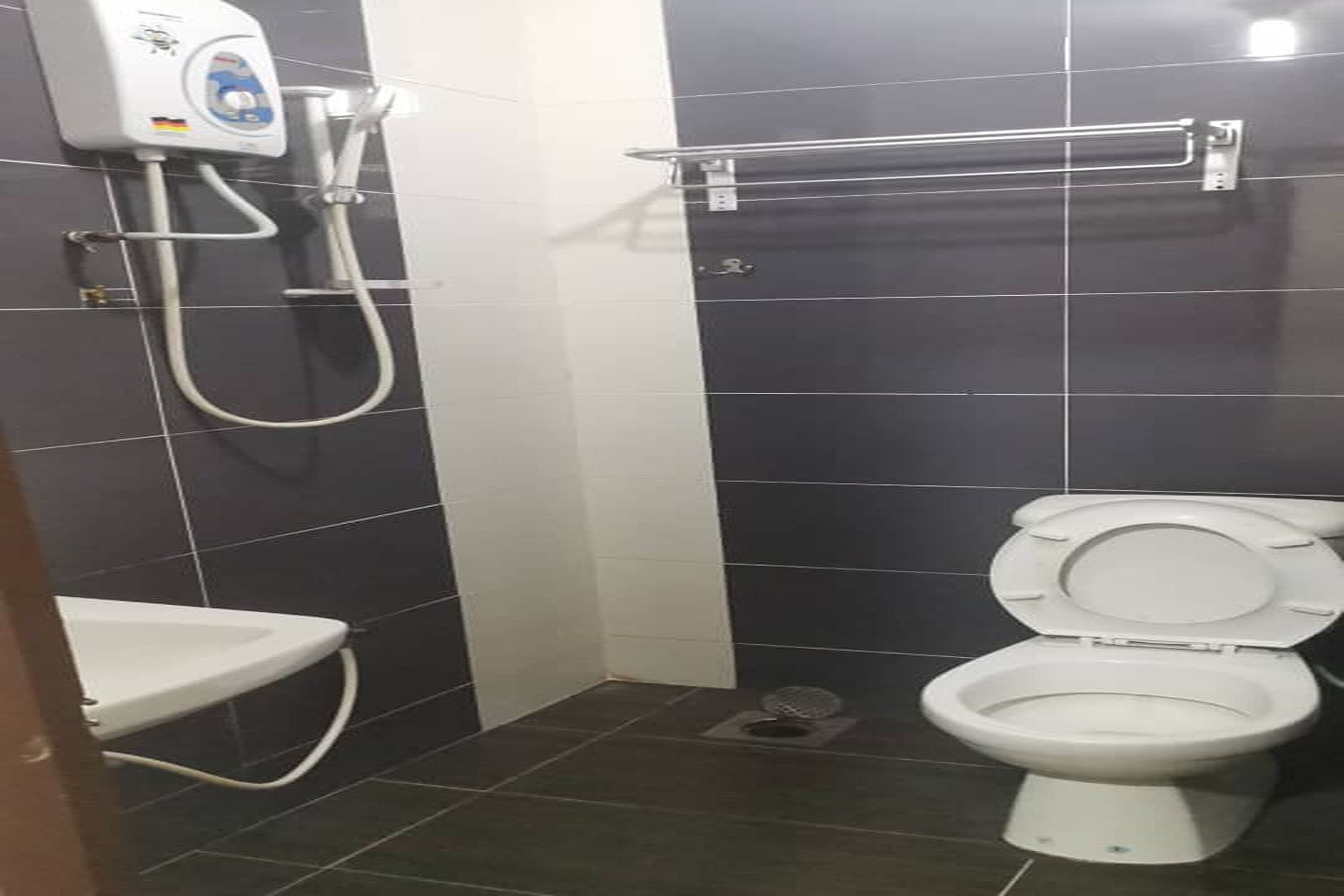 Une petite salle de bain comprenant des toilettes, une douche et un lavabo.