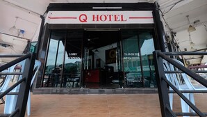 Der Eingang zum Q Hotel mit einer Rezeption und einer gut sichtbaren Telefonnummer.