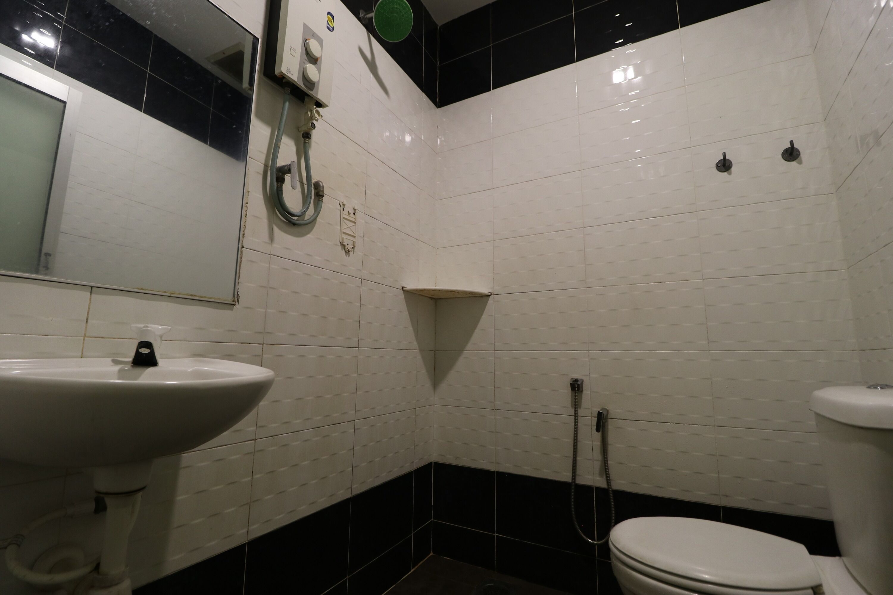 A bathroom with a white sink, a toilet, and a shower area.