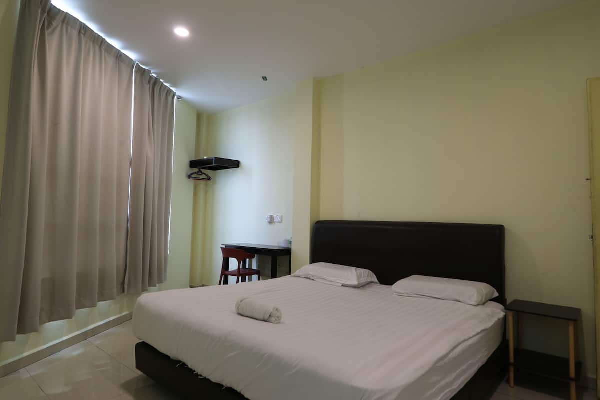 Una habitación de hotel con una cama, un escritorio y una silla.