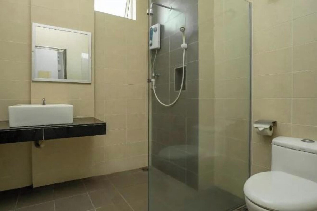 A bathroom with a glass-enclosed shower, a white sink, and a toilet.