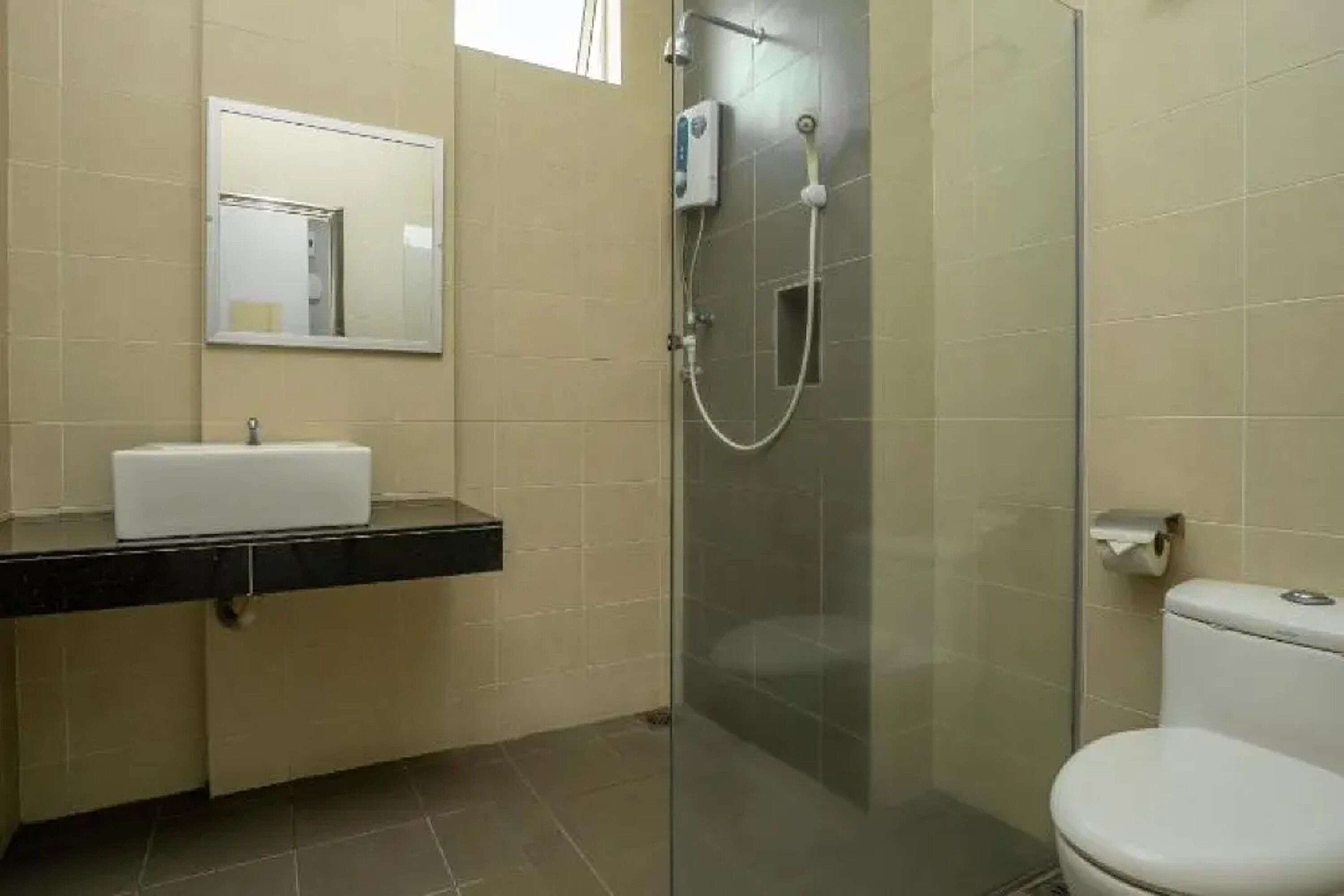 A bathroom with a glass-enclosed shower, a white sink, and a toilet.