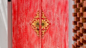A red wooden door with a decorative emblem.