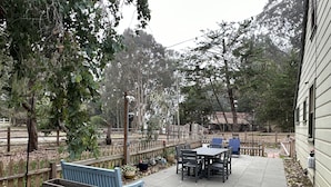 A patio with outdoor seating, a wooden bench, and a table. - Harbor Kee Peaceful Escape By The Bay (Bodega Bay)