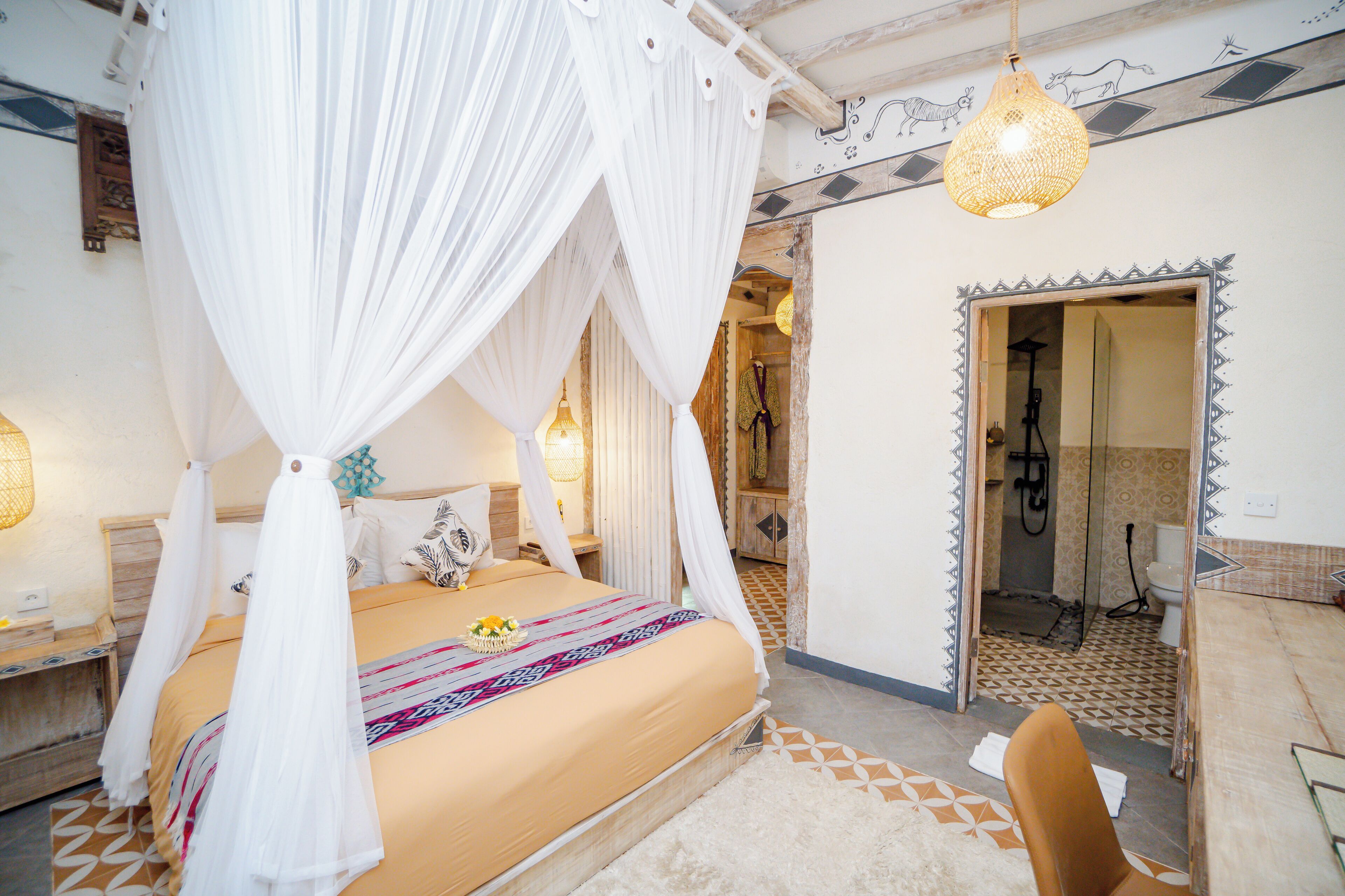 A bedroom with a four-poster bed, a bathroom with a shower, and a mirror with a decorative border.