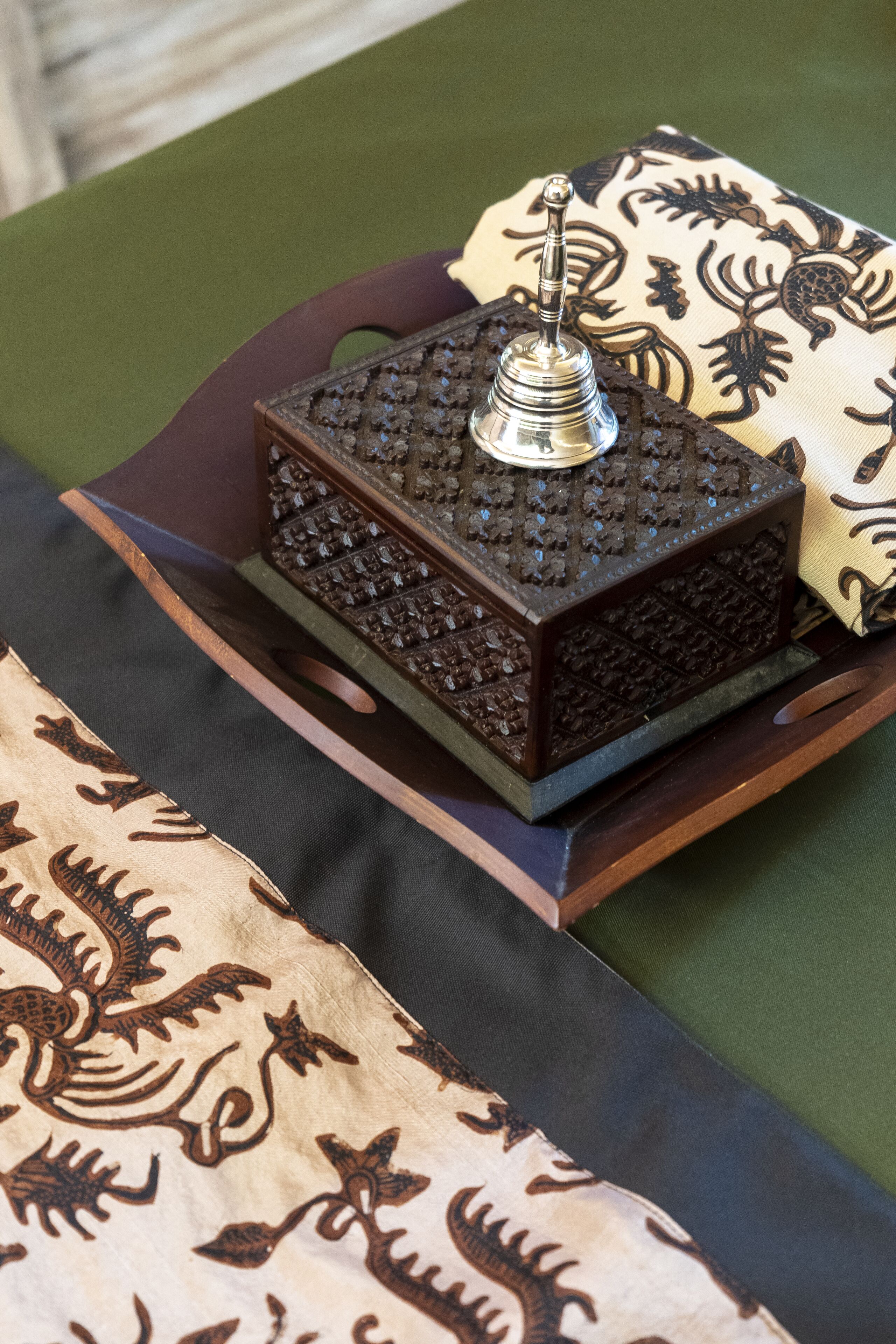 A decorative object with a metallic top and a textured base, placed on a patterned fabric.