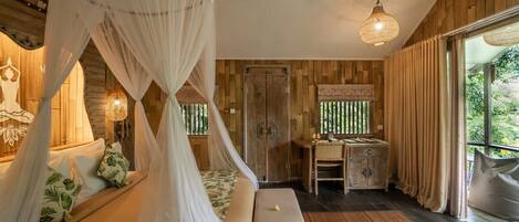Une chambre dotée d’un lit à baldaquin, de murs en bois, d’un ventilateur de plafond, d’un bureau avec une chaise et d’une grande fenêtre.