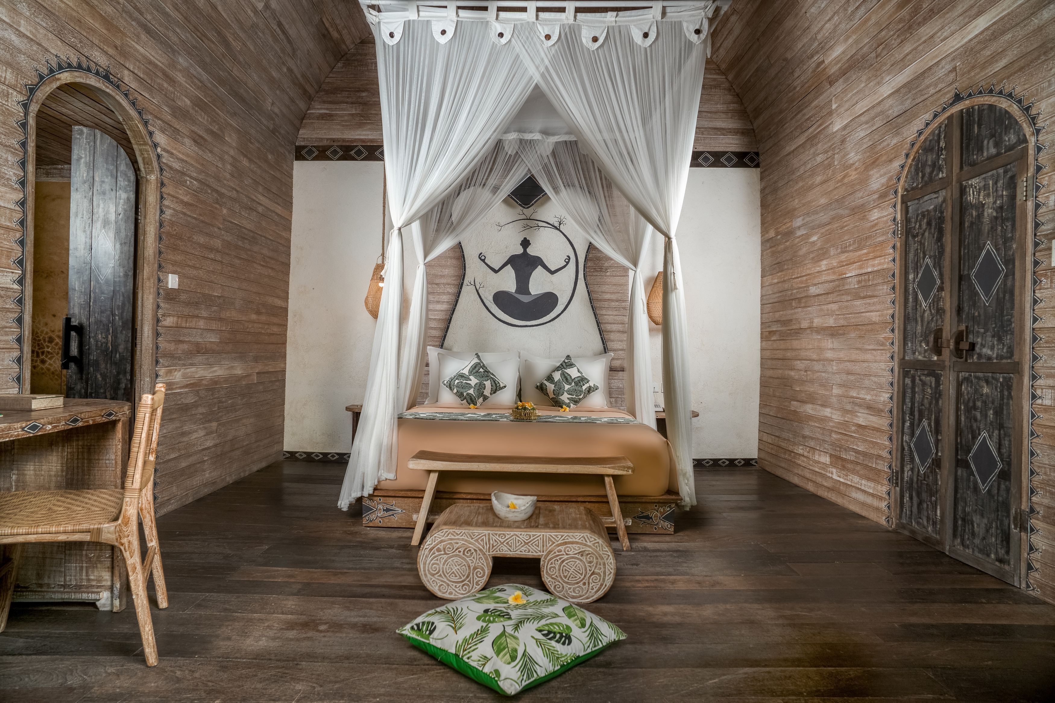 A room with a bed, a small table, and a chair.