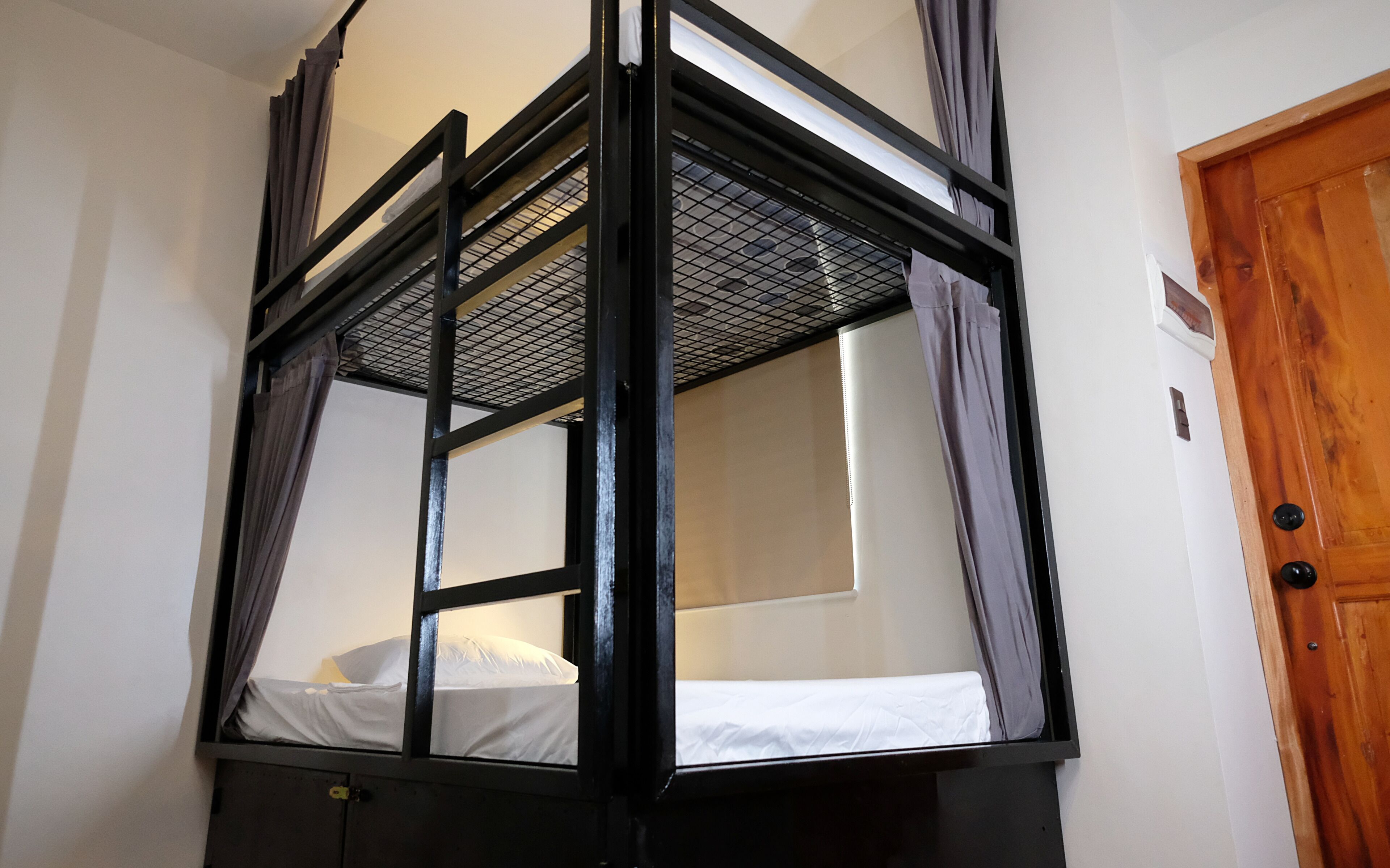 Una cama litera con estructura metálica y dosel de malla.