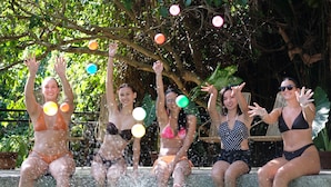 A group of people sitting by a pool with water splashing around them. - Mad Monkey Dumaguete (Dumaguete)