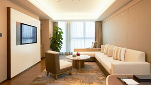 A modern hotel room with a sofa, armchair, and a coffee table. - LN Dongfang Hotel Pazhou (Guangzhou)
