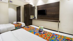 A hotel room with two beds, a TV mounted on the wall, a wardrobe, and a small table with a remote control. - FabHotel Eleanora Inn (Barasat)