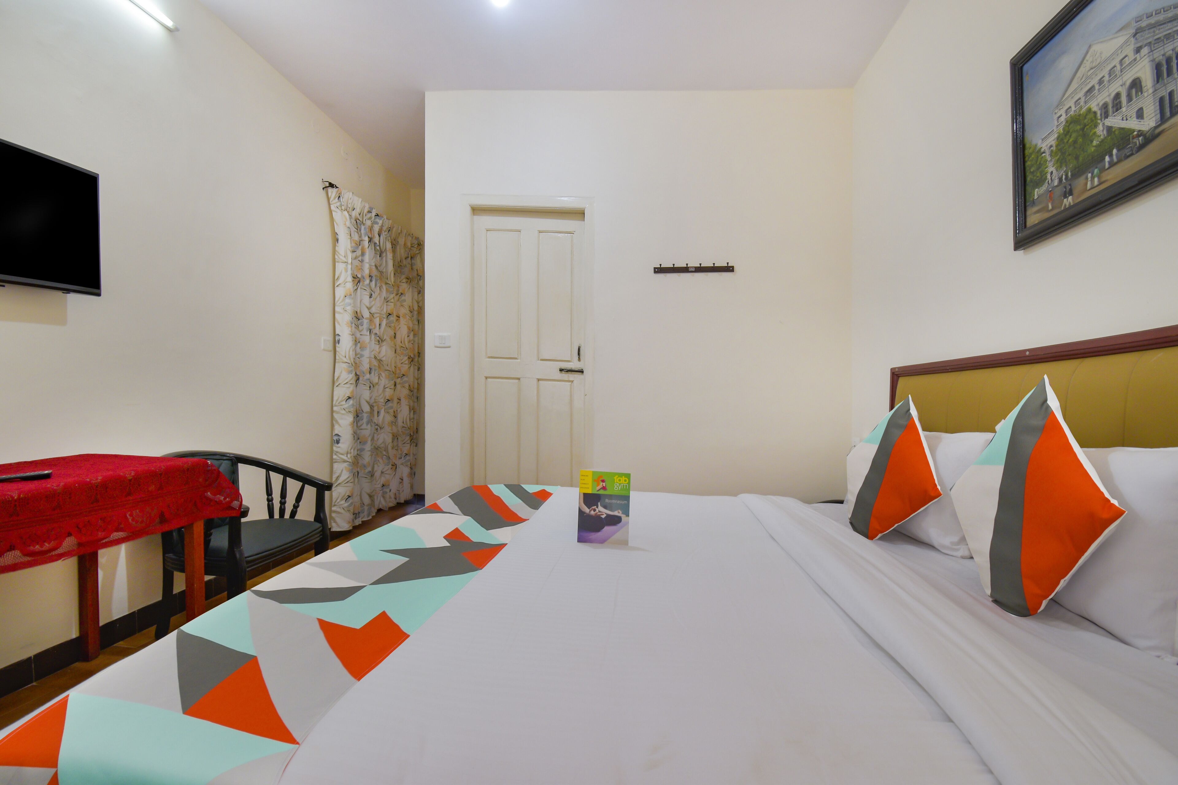 Una habitación de hotel con cama, televisión, mesa y silla.