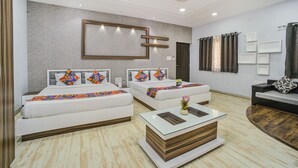 A modern hotel room with two beds, a glass coffee table, and a seating area with a sofa and armchairs. - FabHotel Bee Town - AB Road (Indore)