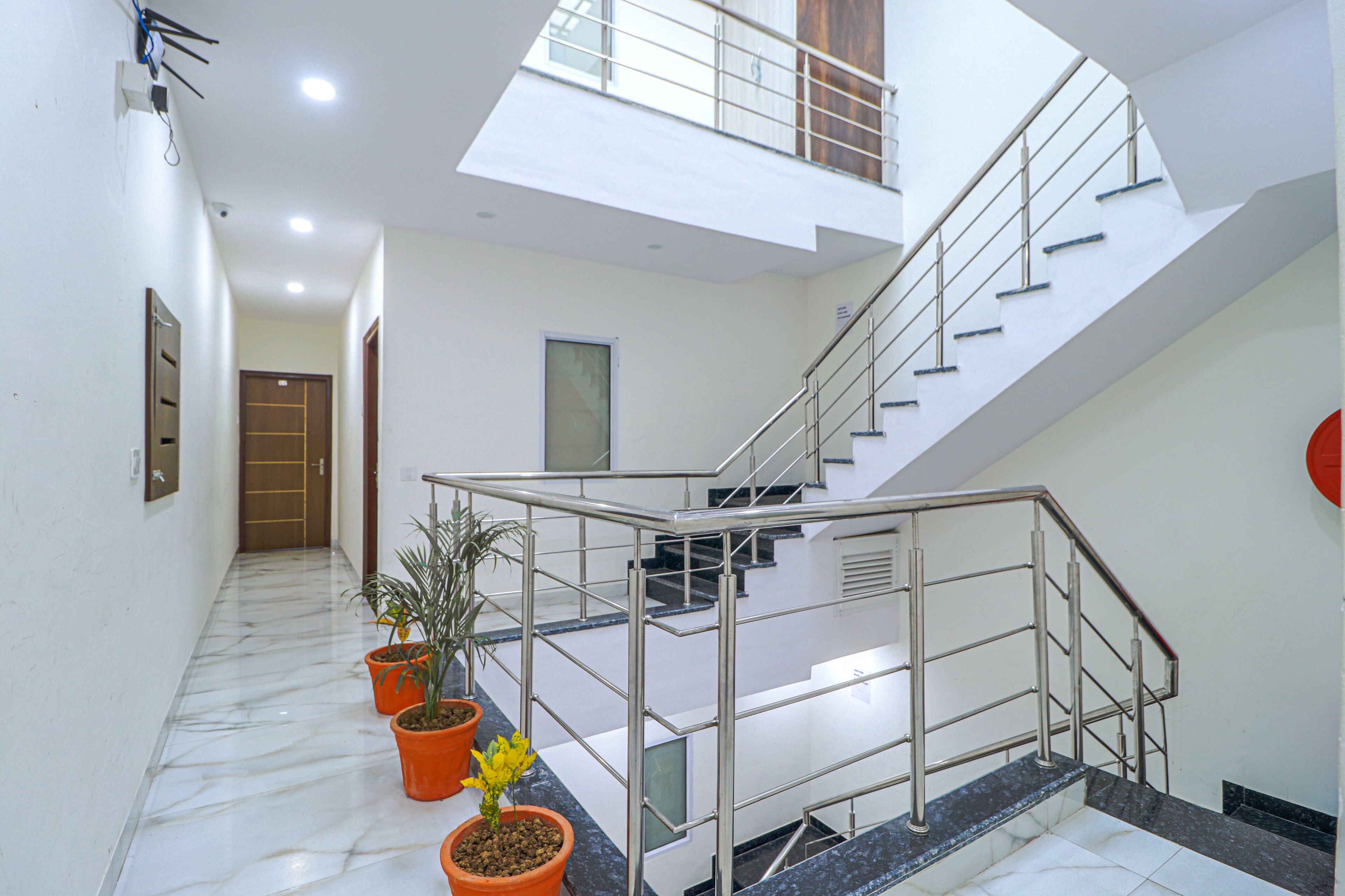 A modern interior with a staircase, potted plants, and a skylight. - Fabhotel Casa (Mohali)